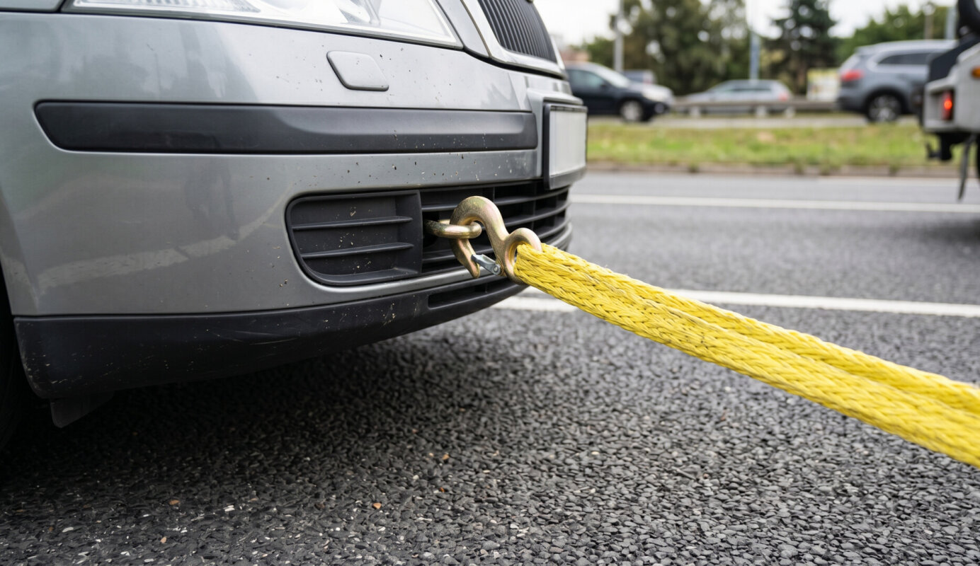Linka holownicza zamocowana do ucha holowniczego w samochodzie.