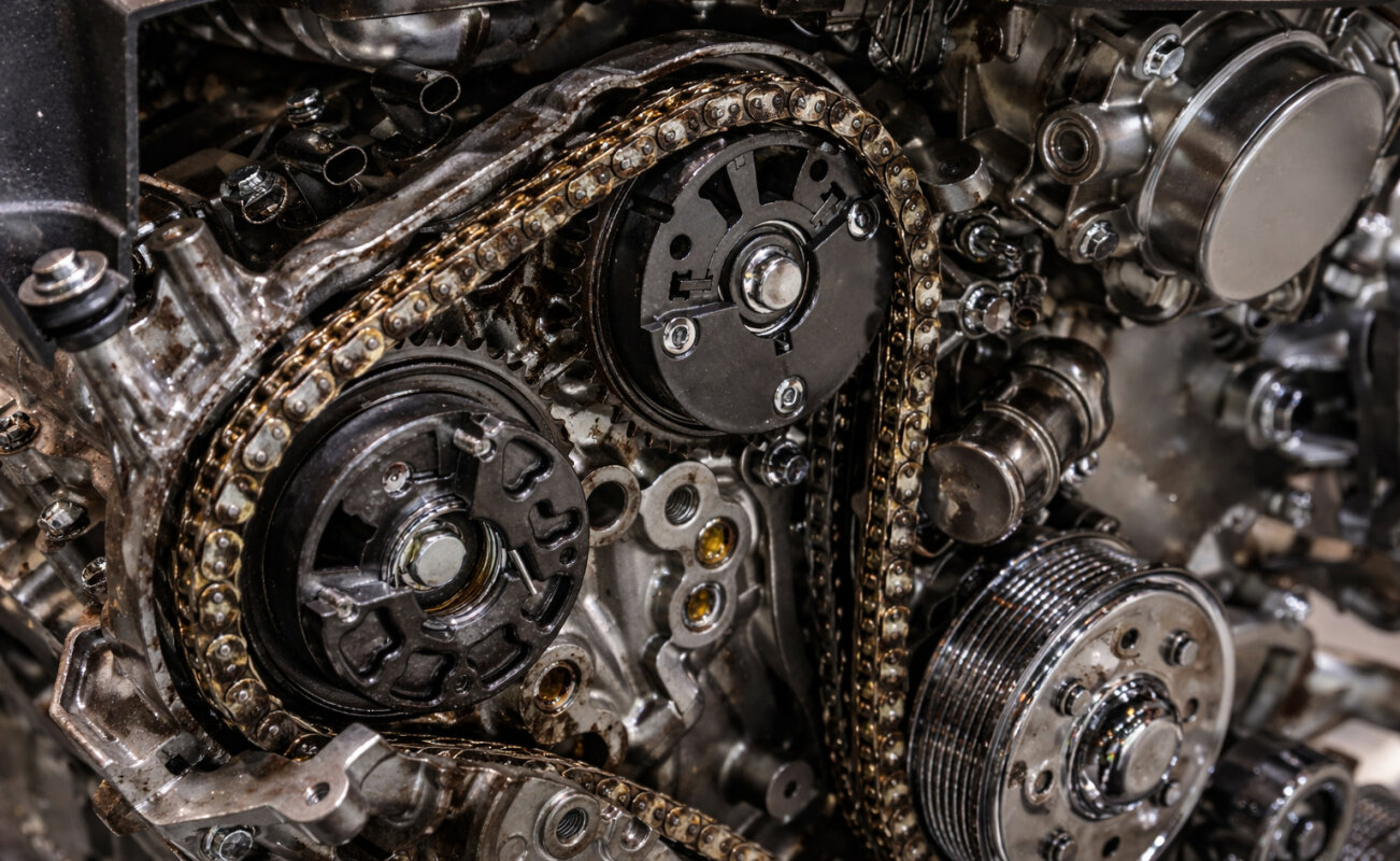 Rozciągnięty łańcuch rozrządu w silniku z osadem oleju, zbliżenie.