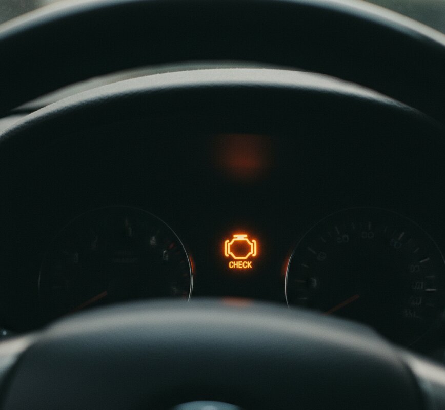 Pomarańczowa kontrolka 'Check Engine' świecąca się na desce rozdzielczej samochodu.